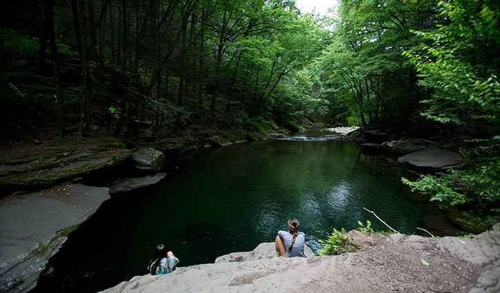 peekamoose blue hole with girl sitting on a rock