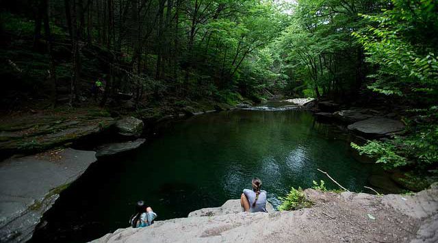 peekamose blue hole with girl sitting on a rock