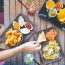 Girl picking up toast from a table spread with vegetarian Mexican food