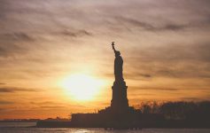 Statue of Liberty silhouetted against a sunrise