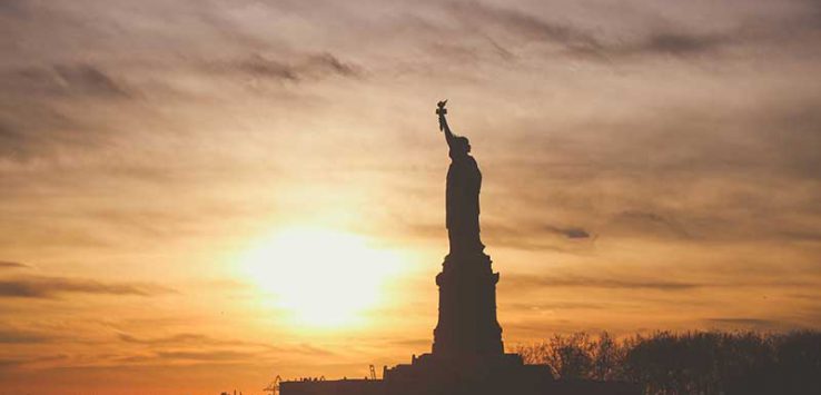 Statue of Liberty silhouetted against a sunrise