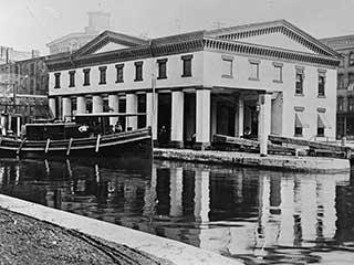 Historic image of the Erie Canal Weighlock Building before the canal was paved over