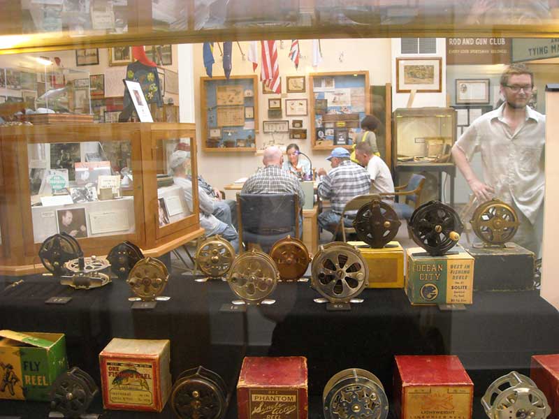 Glass display case filled with fly fishing reels at Catskill Fly Fishing Center & Museum