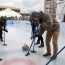 A family learning the sport of curling on an ice rink