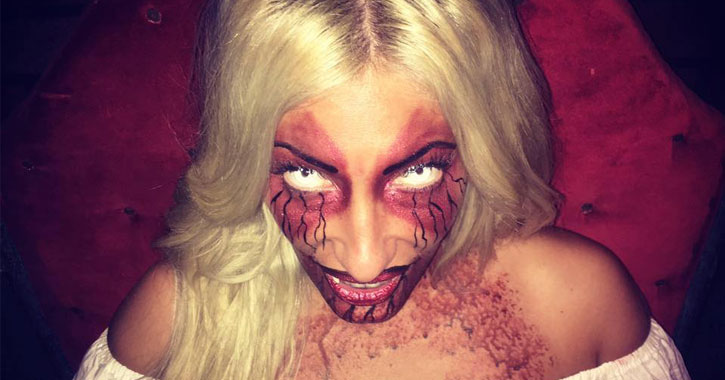 a scary demon-like girl with blonde hair and red and black makeup, empty eyes